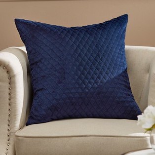Navy Quilted Velvet Cushion sitting on cream fabric Armchair