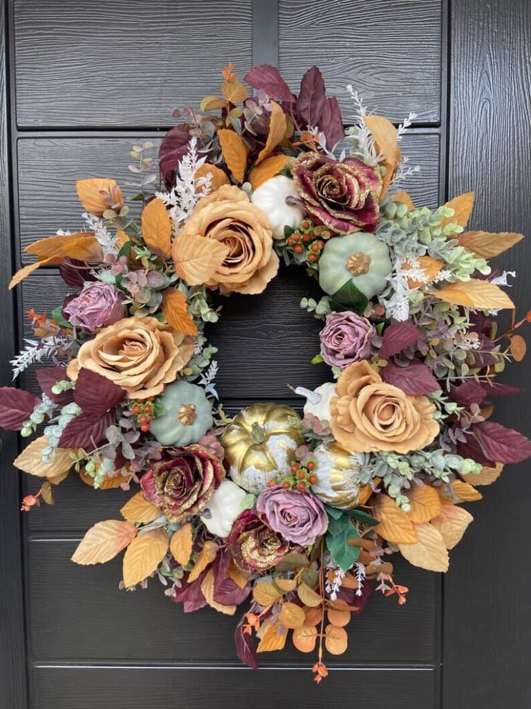 A large, glamorous pumpkin wreath. With golden dusted plum roses, golden topped teal pumpkins & golden pumpkins.