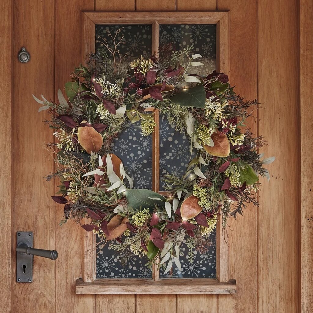 Autumn toned foliage mixed wreath hanging on a door