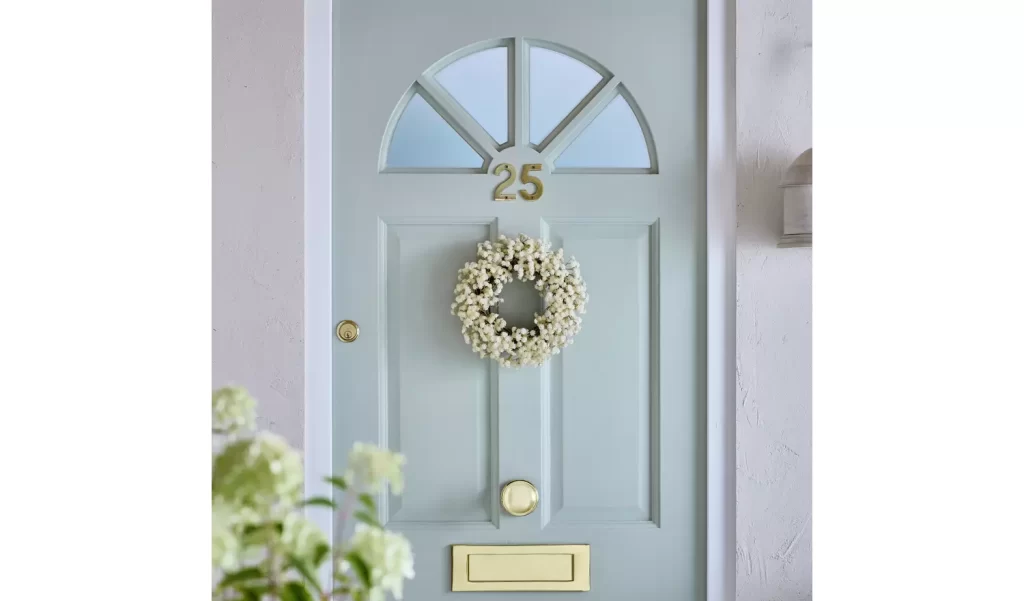 Front door with a small neutral faux wreath.