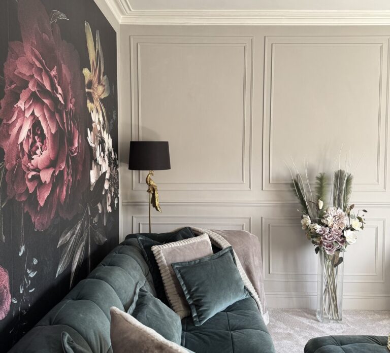 Moody luxe style living room renovation featuring greige panelled walls, large floral wall mural, and coordinated soft furnishings. After renovation image.