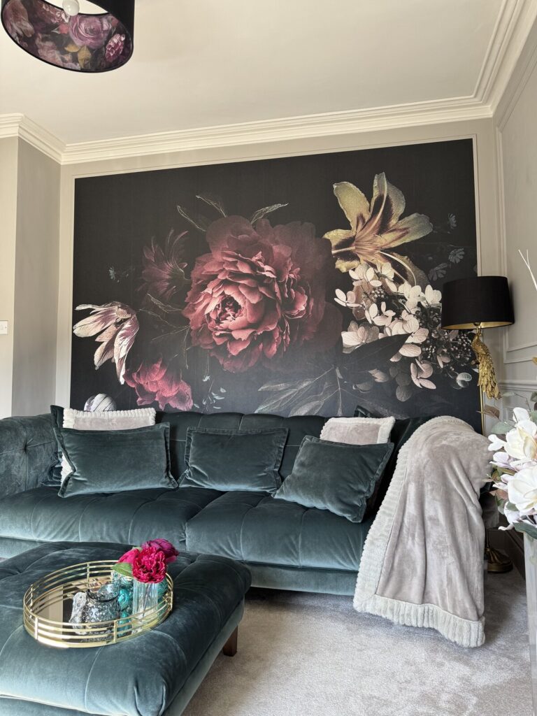 Moody luxe style living room renovation featuring greige panelled walls, large floral wall mural, and coordinated soft furnishings. After renovation image.