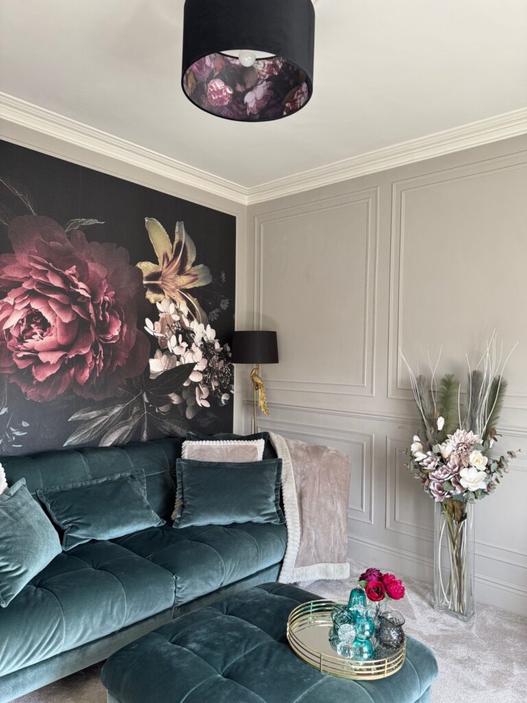Moody luxe style living room renovation featuring greige panelled walls, large floral wall mural, and coordinated soft furnishings. After renovation image.
