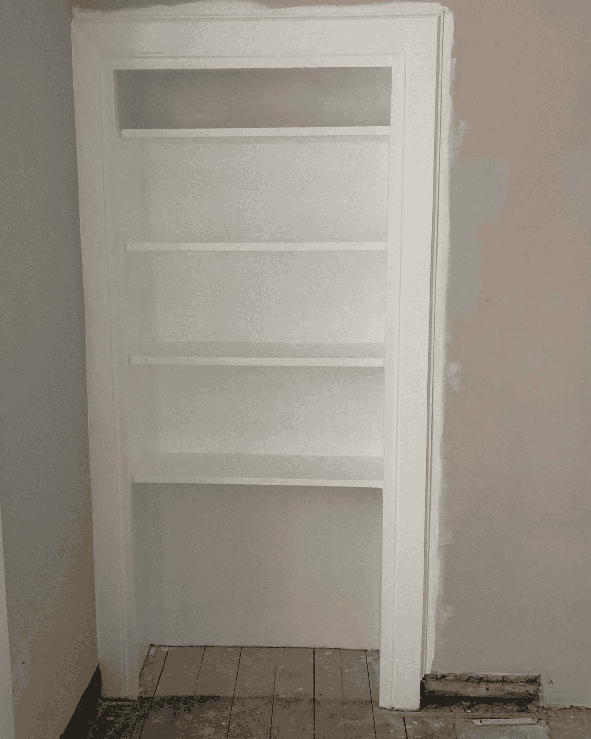 Original shelving freshly painted white - mid renovation.