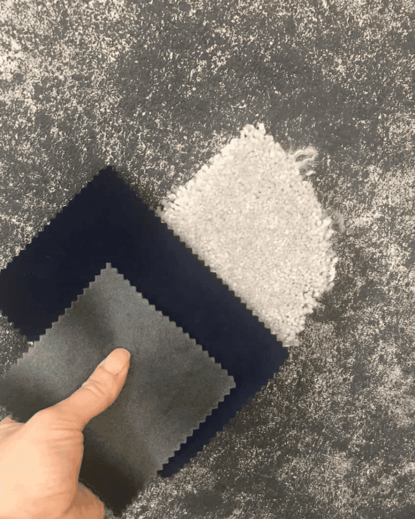 Carpet and fabric samples placed against a navy blue textured wallpaper checking they all work together.