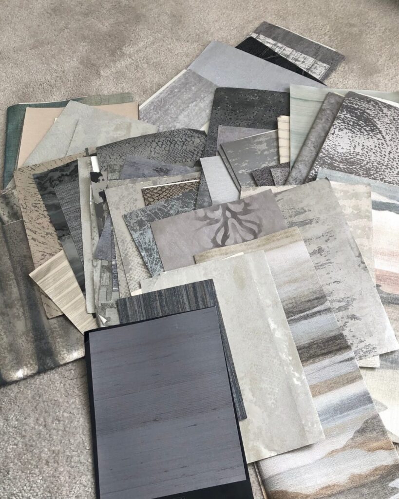 Collection of wallpaper samples, mostly metallic neutrals and greys.